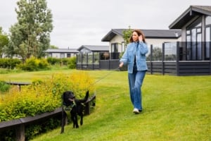 Alex Jones walking a dog outside lodges at Unity Beach holiday park.